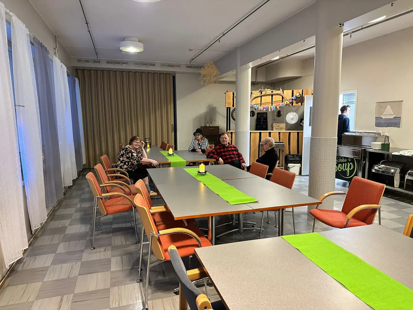 Avara ruokailutila pitkine pöytineen ja korkeine ikkunoineen Kurimon majatalossa